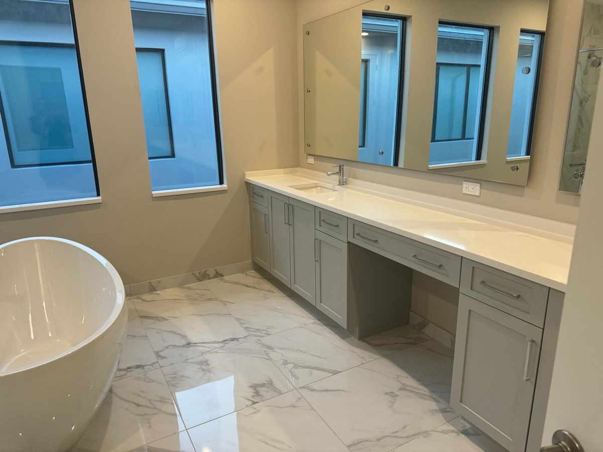 Modern kitchen with custom white shaker cabinets and marble countertop