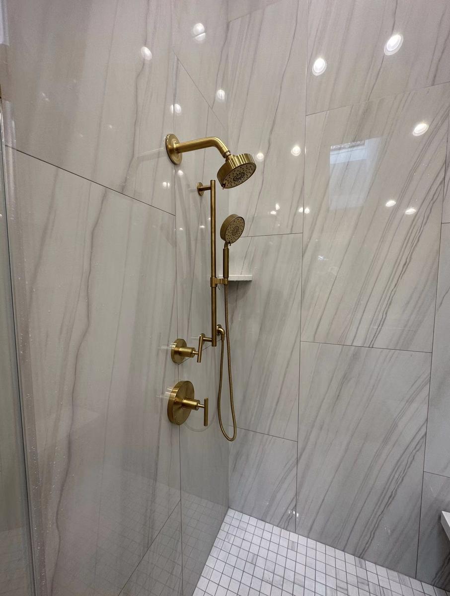 Polished gold bathroom fixtures and faucet in luxury residential renovation by Lion Construction Management