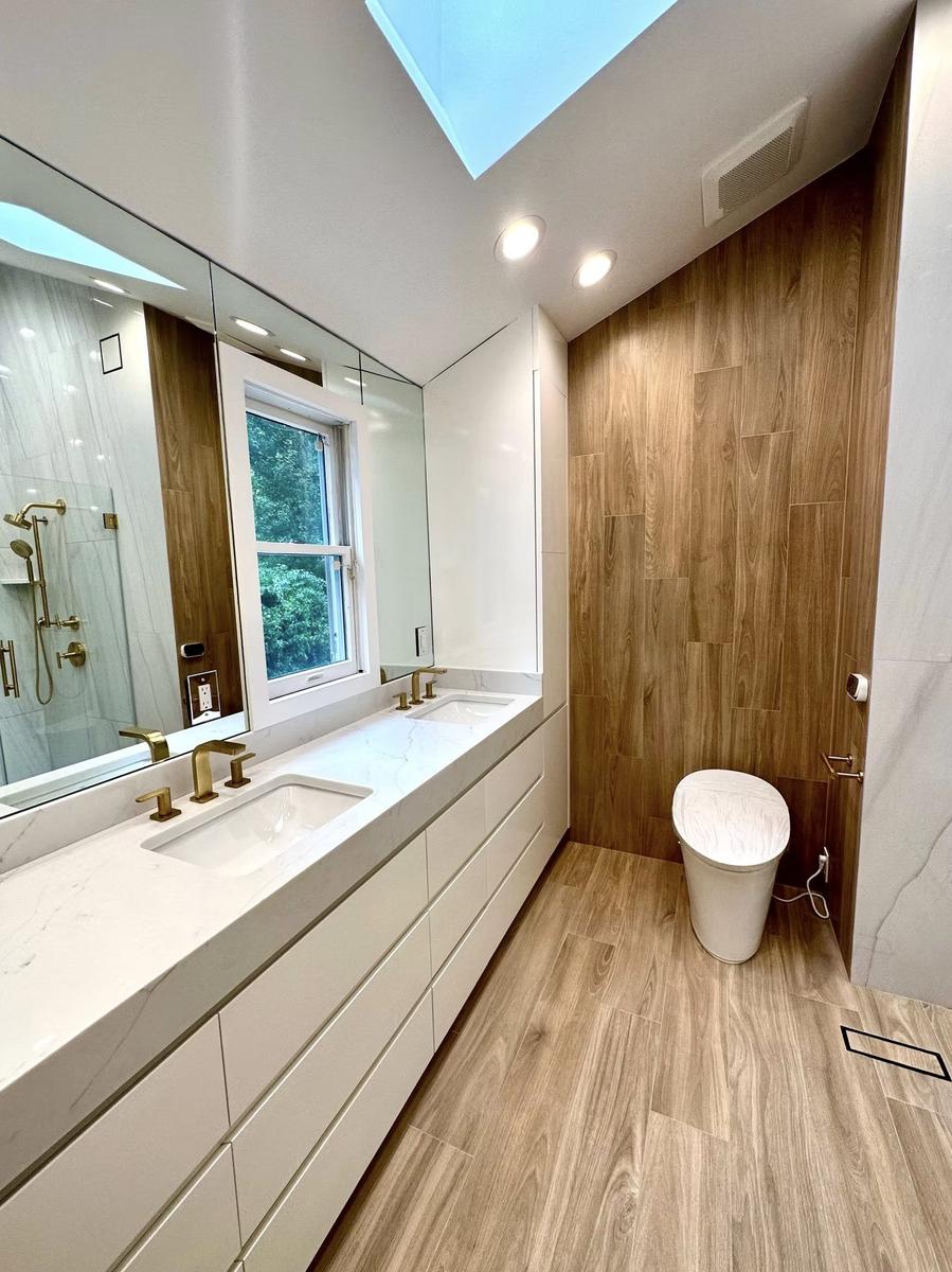 Skylight above custom walnut bathroom vanity casting natural light in luxury renovation
