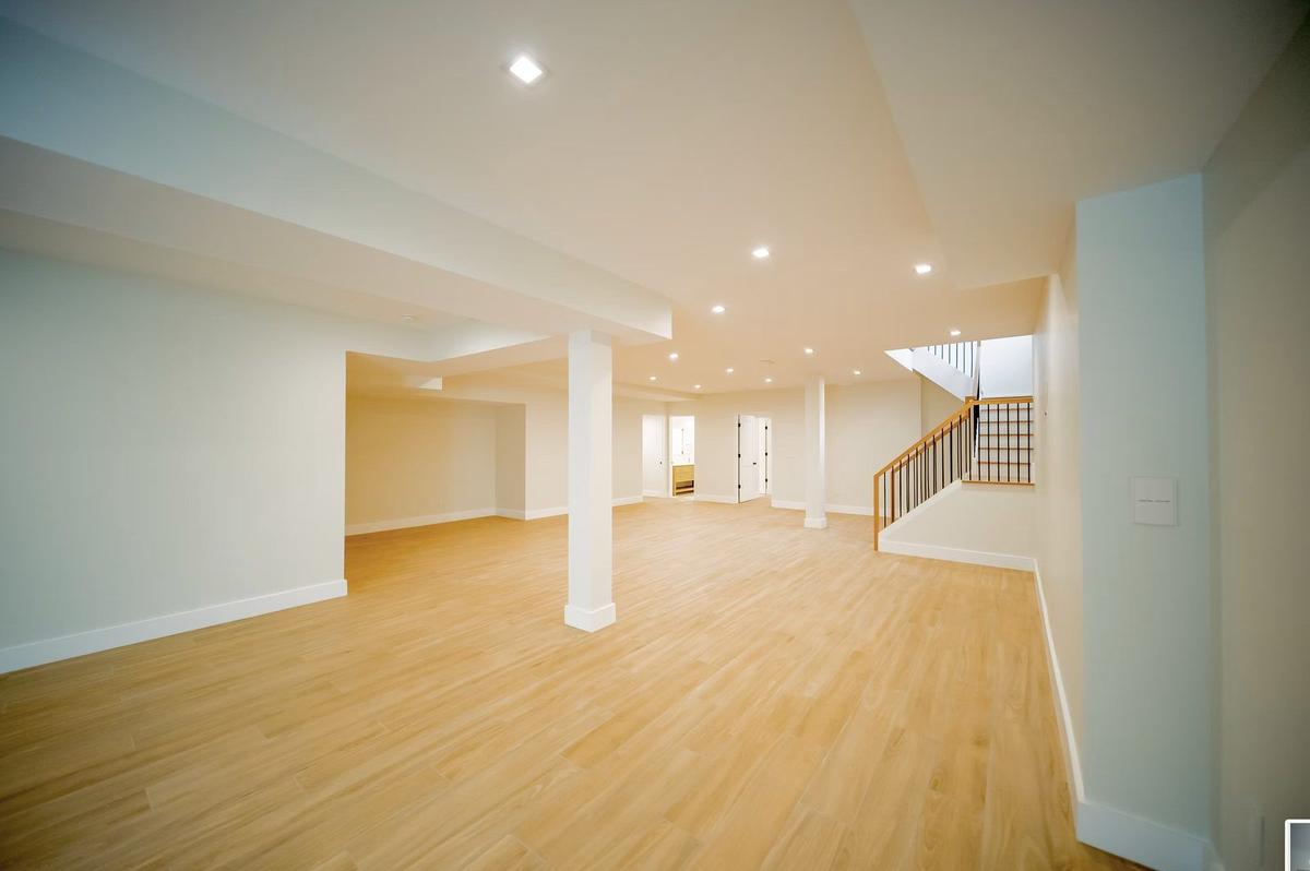 Finished basement with custom built-ins and recessed lighting in East Hampton custom home