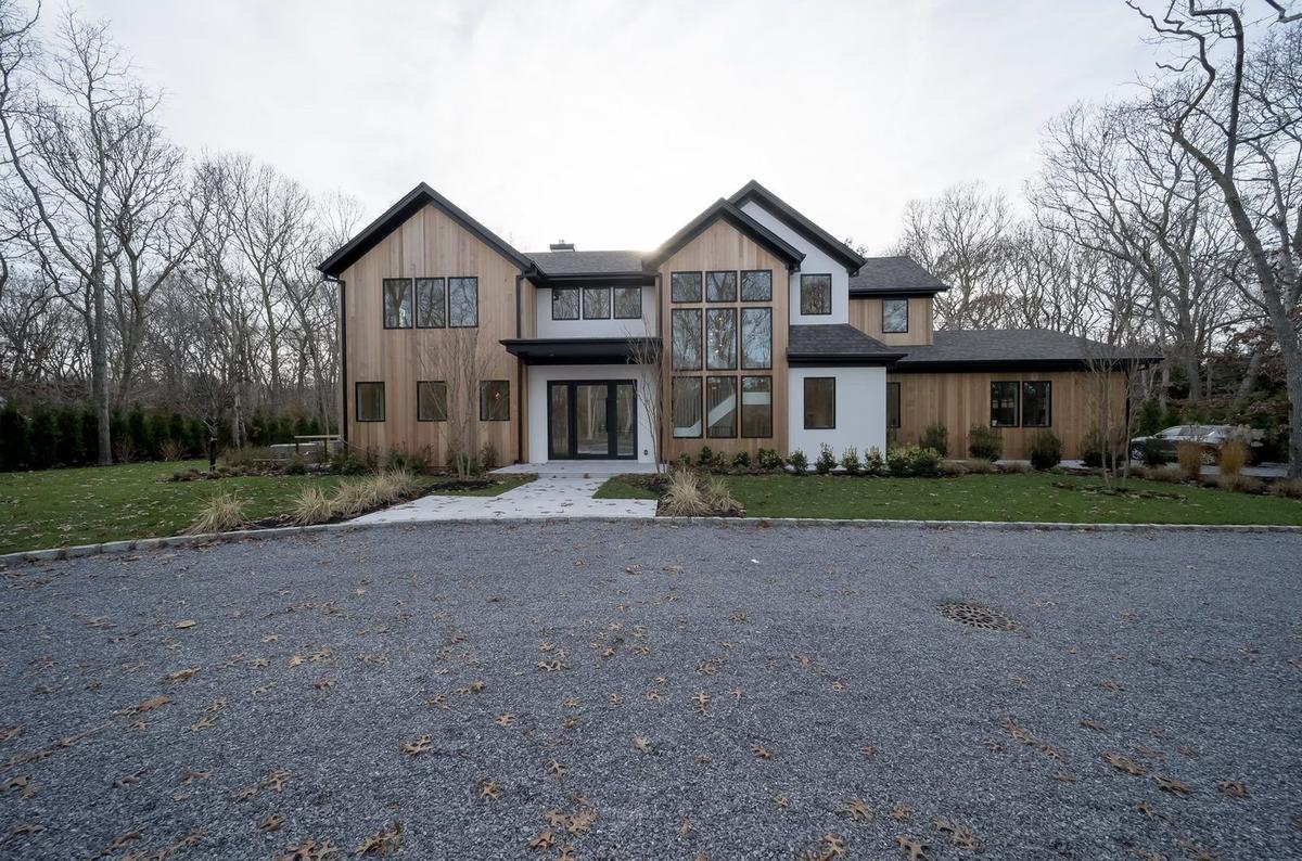 Front exterior of custom-built modern farmhouse with board-and-batten siding in East Hampton