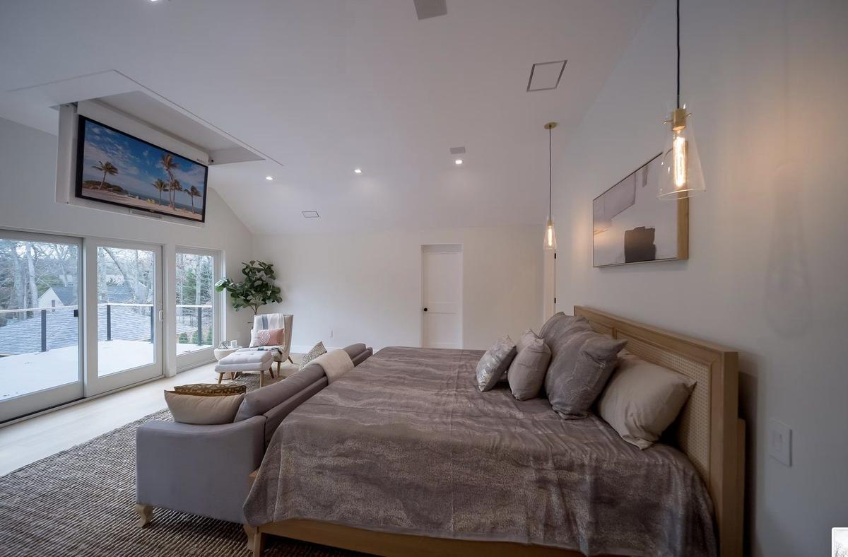 Master bedroom with custom crown molding, recessed lighting, and wood flooring