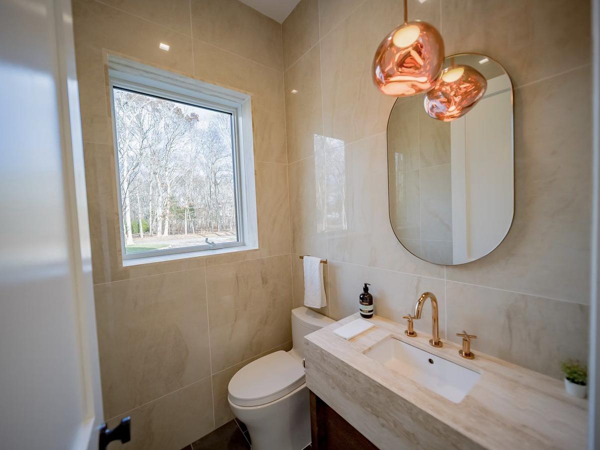 Powder room with custom vanity, vessel sink, and decorative wallpaper