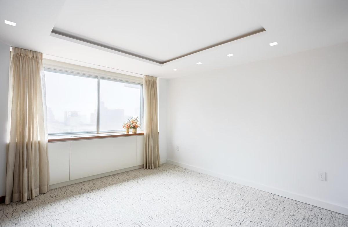 Bedroom with custom tray ceiling, recessed lighting, and crown molding detail