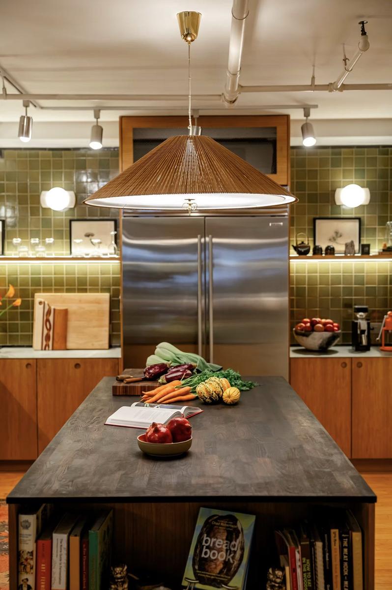 Kitchen island with waterfall countertop and pendant lighting in NYC loft renovation