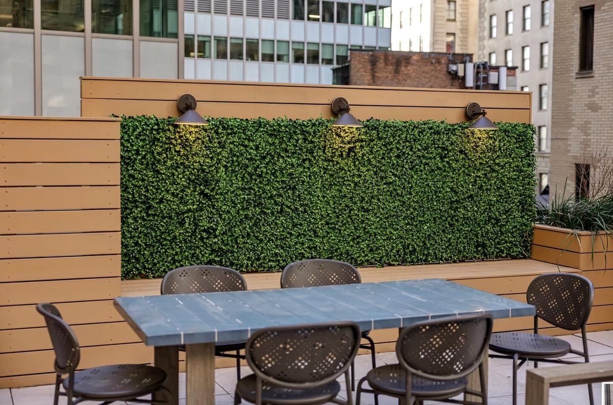 Rooftop terrace dining area with living green wall installation in NYC