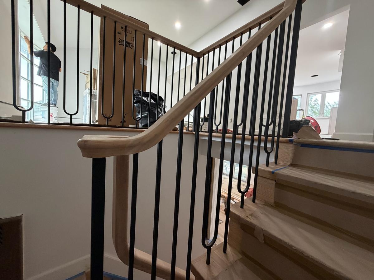 Custom iron balusters with oak handrail and curved newel post