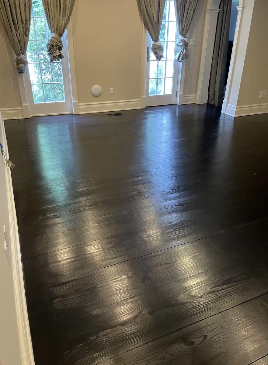 Dark-stained hardwood floor refinishing showing rich wood grain in estate renovation