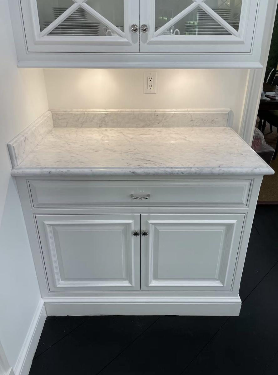 White kitchen renovation with custom cabinetry, marble countertops, and professional appliances