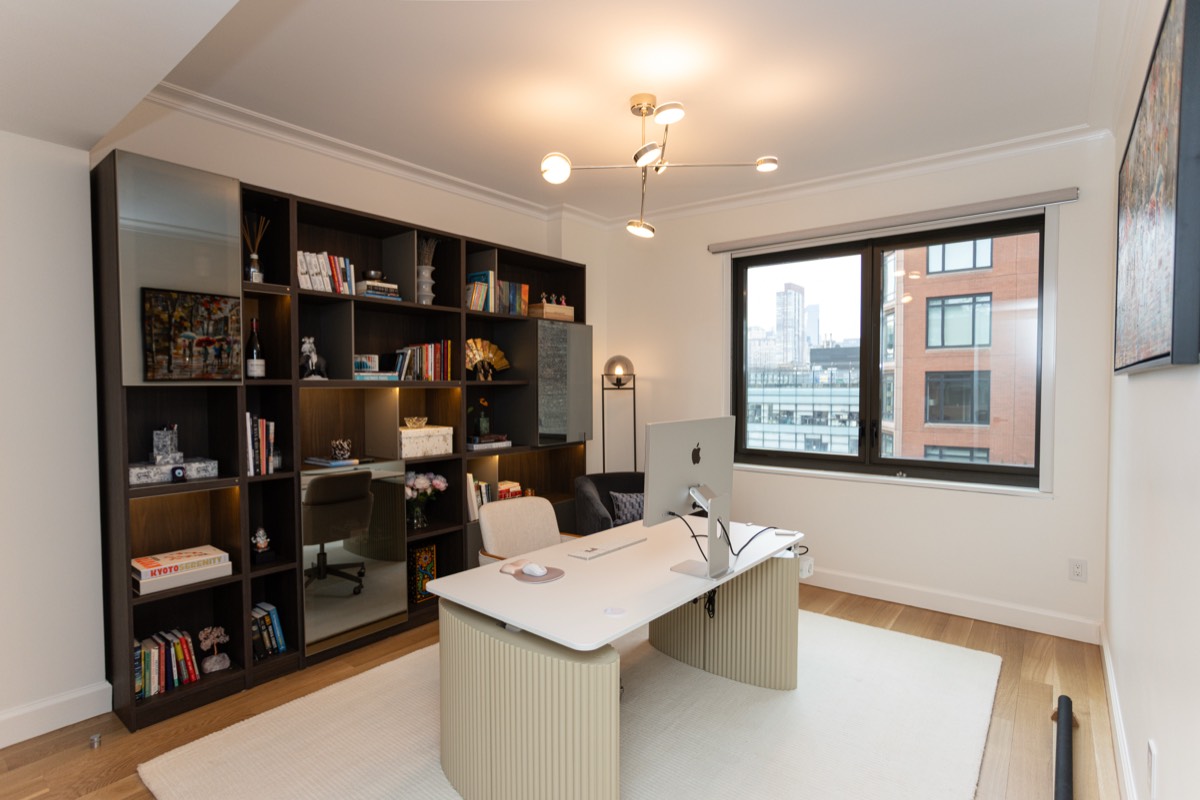 Home office with a full wall of dark built-in shelving and a city view